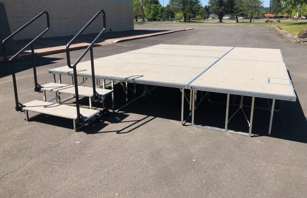 white outdoor carpeted stage with stairs