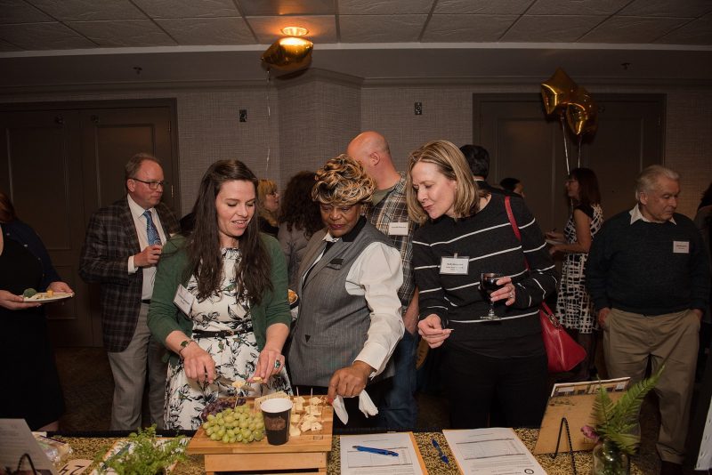 women looking at grape and cheese plate at event women looking at grape and cheese plate at event