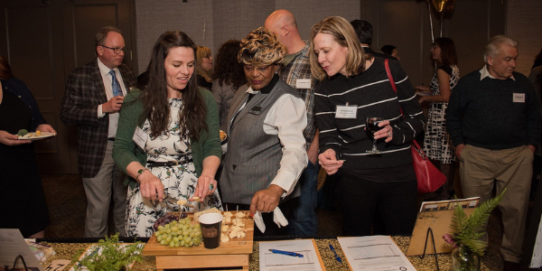 three women at table with grapes and cheese