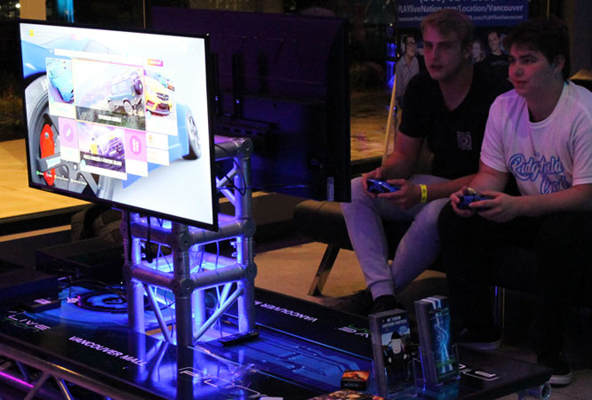 two men playing video games at a party two men playing video games at a party