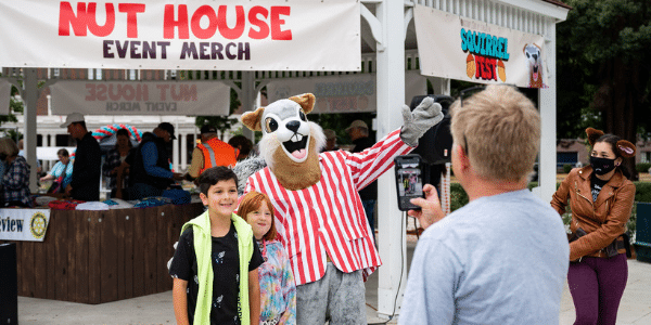 Children taking a photo with a squirrel mascot at Squirrel Fest Children taking a photo with a squirrel mascot at Squirrel Fest