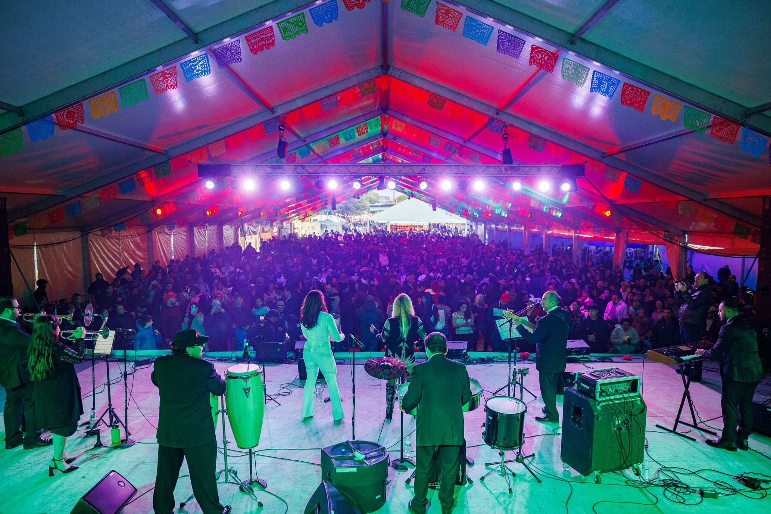 a group of people on stage with a large crowd of people